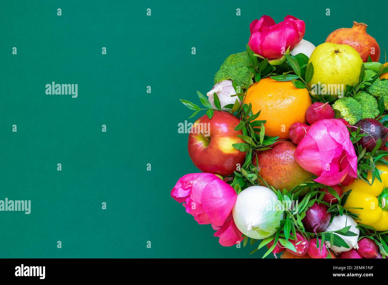 Arrangement de divers légumes et fleurs de printemps sur un fond vert riche. Le concept d'un mode de vie sain Banque D'Images