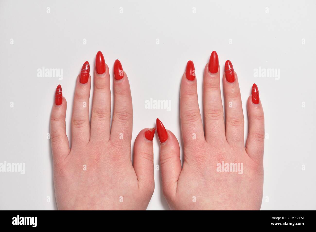 Les mains des femmes avec des ongles rouges en gel renoyés gros plan Banque D'Images