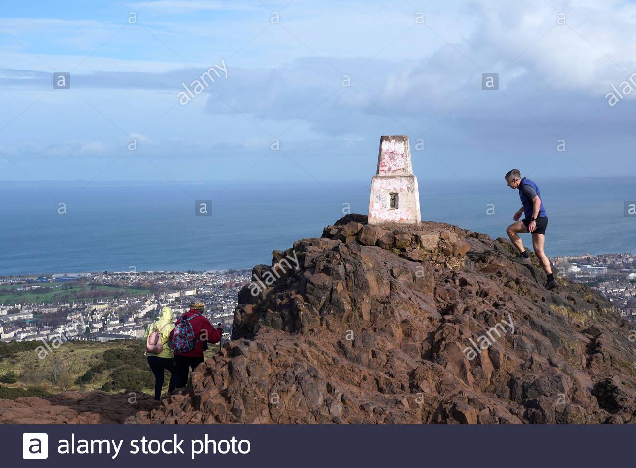 Édimbourg, Écosse, Royaume-Uni. 25 février 2021. Les gens qui profitent du soleil et de l'extérieur dans Holyrood Park. Lutte dans les vents forts sur le sommet de Arthurs Seat. Crédit : Craig Brown/Alay Live News Banque D'Images