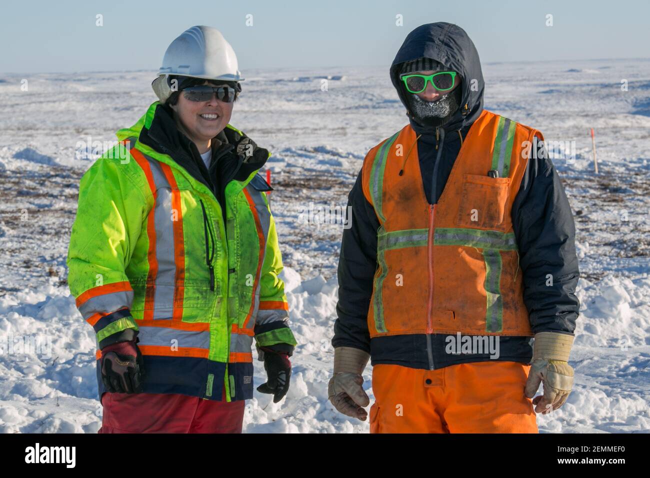 Deux travailleurs sur la route Inuvik-Tuktoyaktuk pendant la construction hivernale, dans les Territoires du Nord-Ouest, dans l'Arctique canadien. Banque D'Images