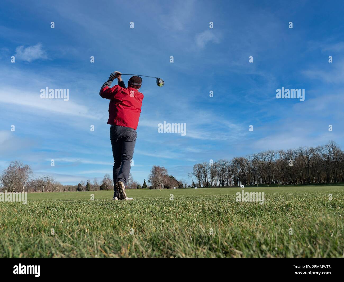 Caen, France, février 2021. Un parcours de golf et un joueur pratiquant un long choc en arrière, de dessous vous pouvez voir l'herbe verte, le ciel bleu Banque D'Images