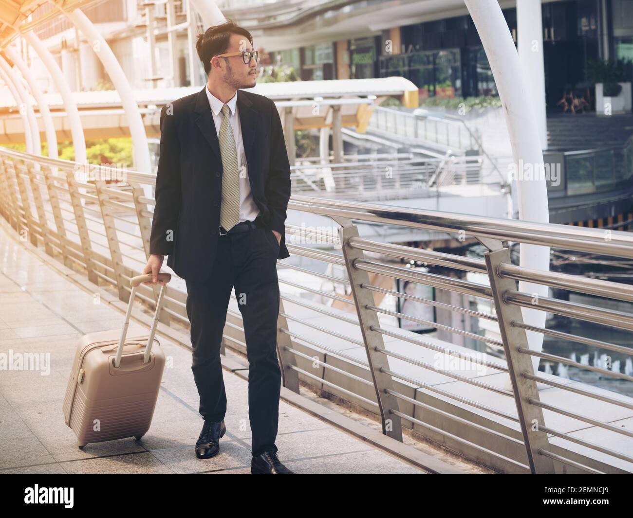 Un homme d'affaires avec un sac de voyage est en voyage d'affaires dans un aéroport international ou une gare à des fins d'affaires. Banque D'Images