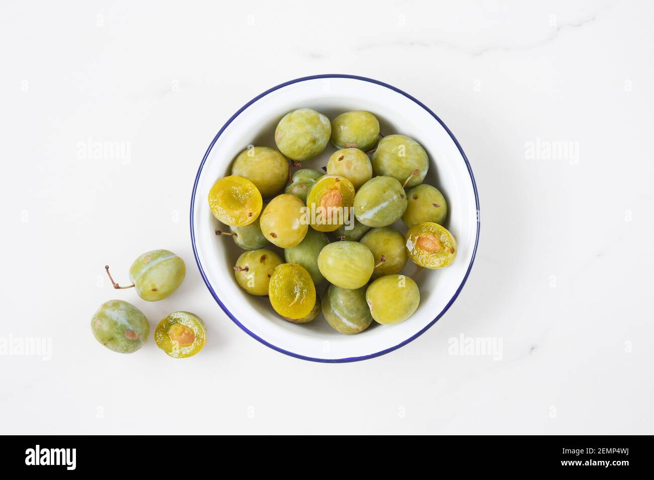 Prunus domestica Reine Claude. Greengages dans un bol. Banque D'Images