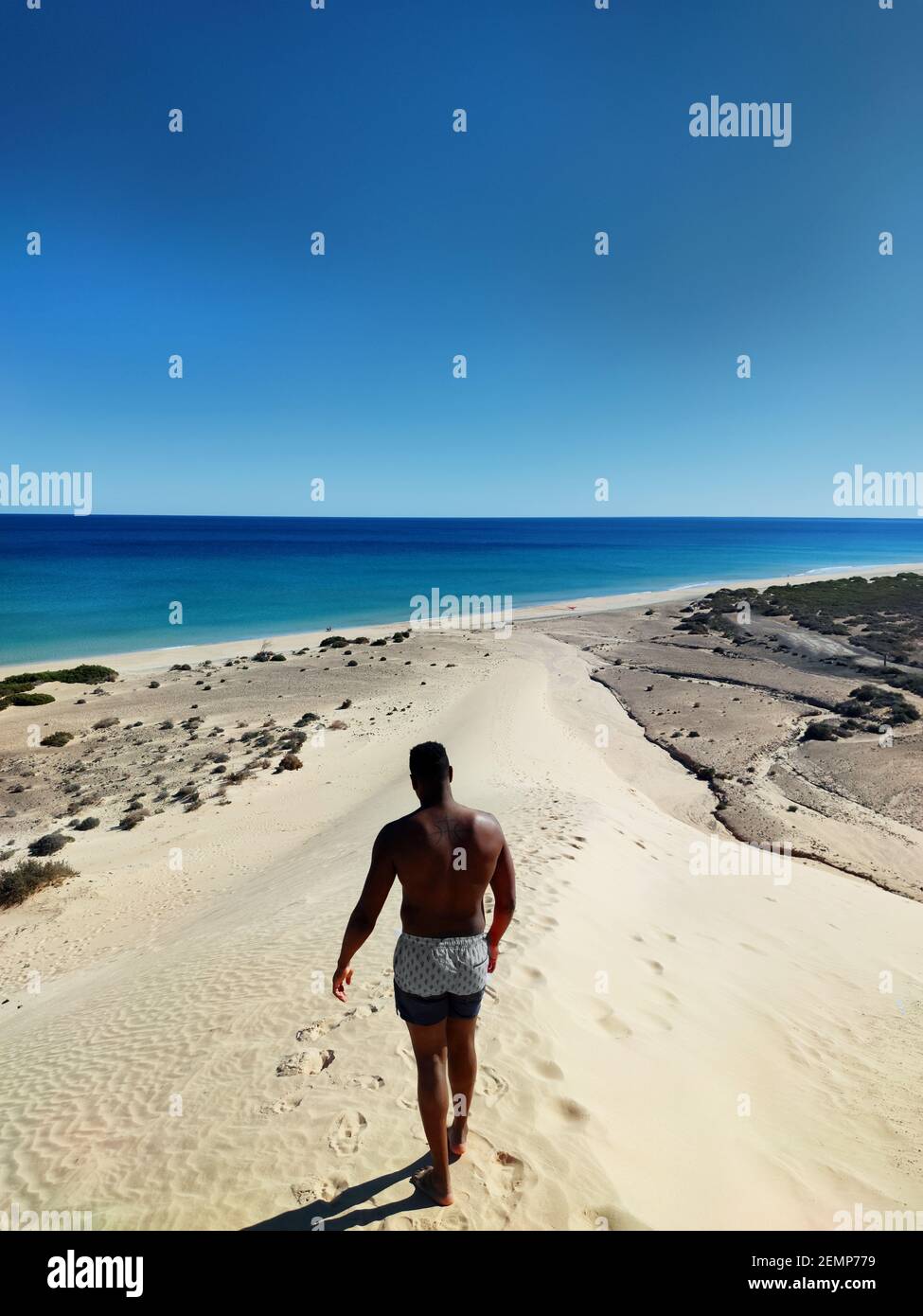 Homme noir marchant sur une dune sur la plage de sotavento, Fuerteventura Banque D'Images