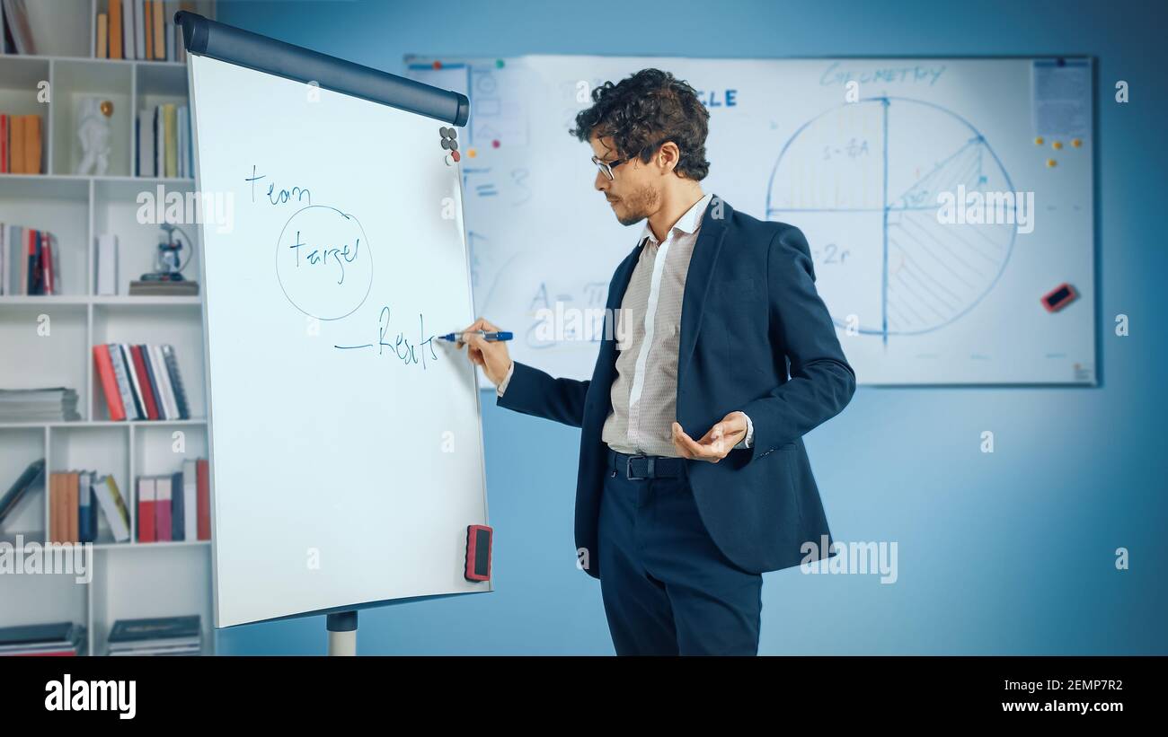 Business Coach for the Company Management explique comment former efficacement votre équipe en écrivant sur Whiteboard. Cours en ligne, travail à distance, vidéo Banque D'Images