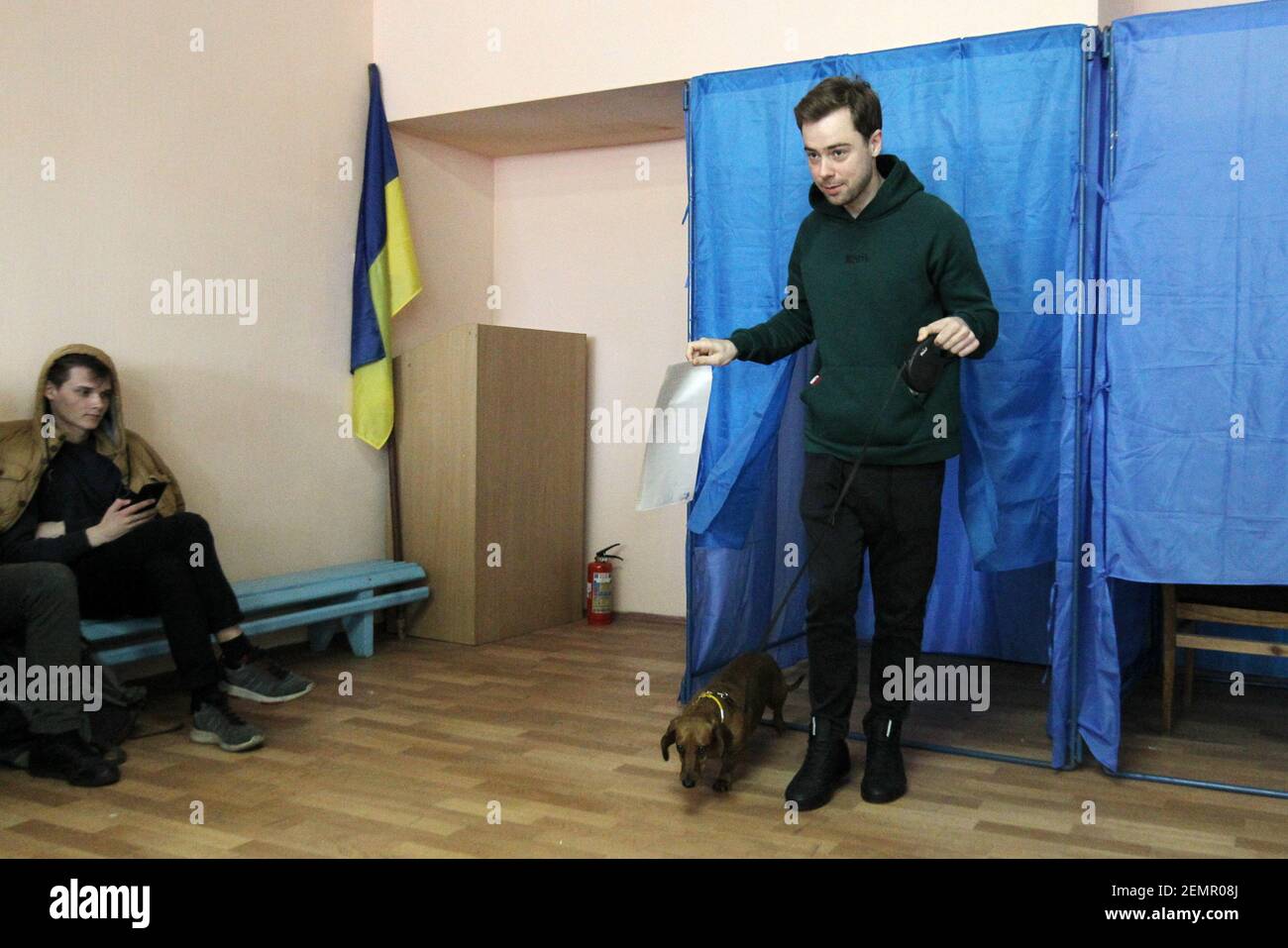 Un homme avec son chien quitte un poste de vote avec un bulletin de vote lors des élections présidentielles ukrainiennes à Kiev, Ukraine, le 31 mars 2019. (Photo par Alex Chitaro/Sipa USA) Banque D'Images