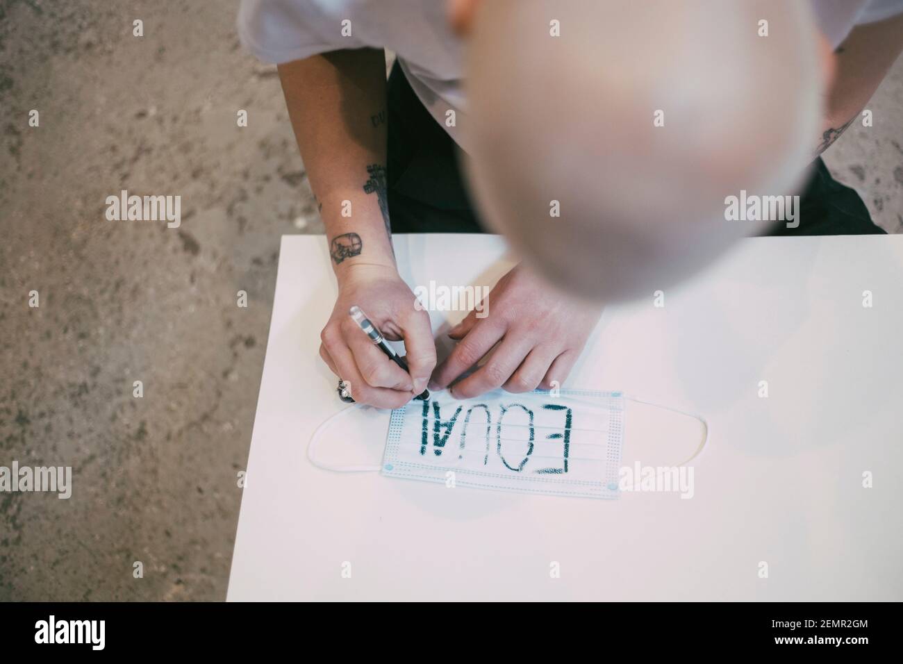 Vue en grand angle de la femme qui écrit sur un masque de protection Banque D'Images