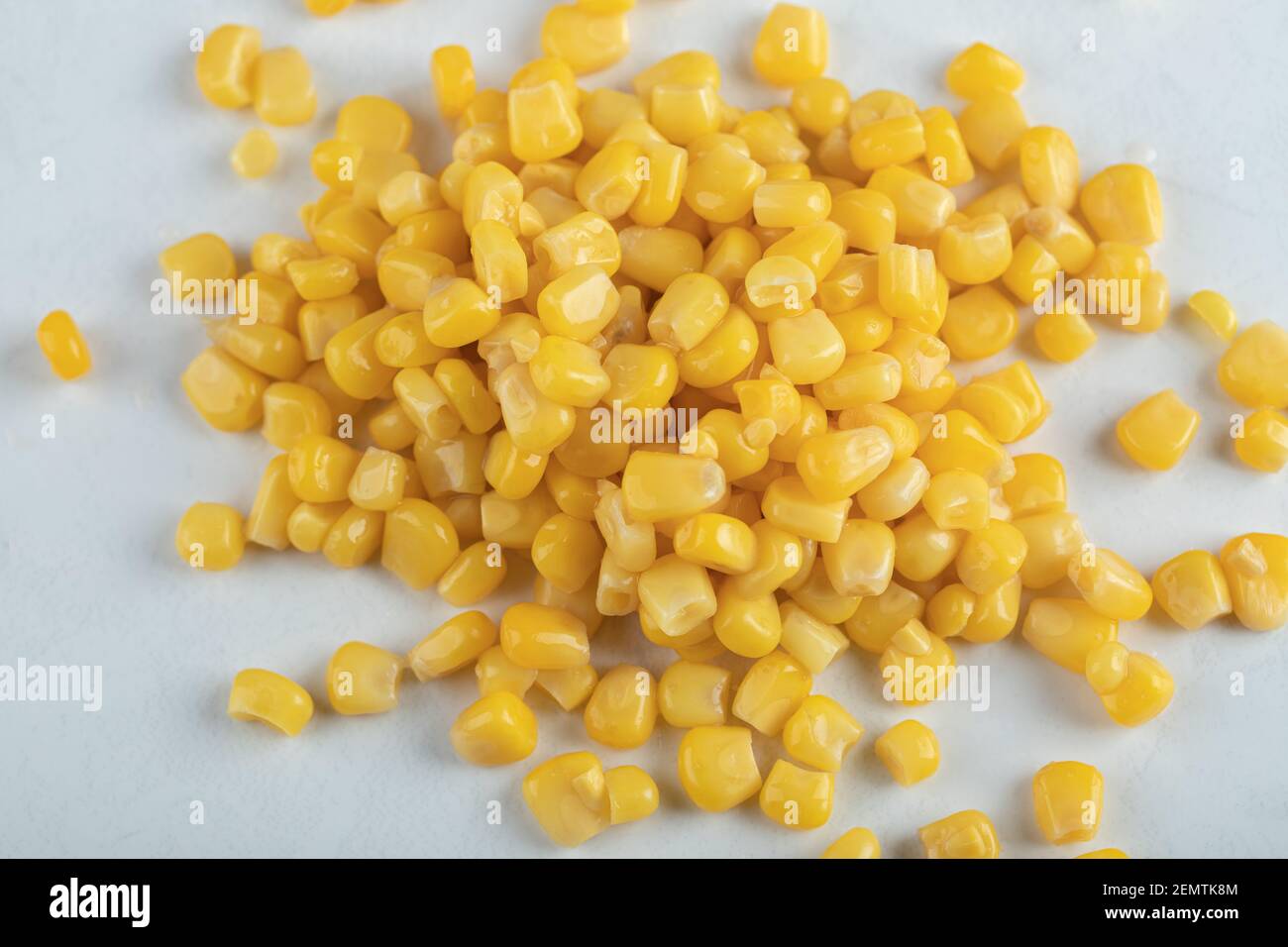 Vue de dessus des graines de maïs en conserve sur fond blanc Banque D'Images