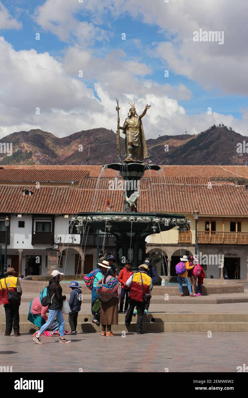 Une fontaine avec une statue du roi Inca Pachacutec sur la place principale de Cusco, au Pérou, avec des locaux rassemblés devant Banque D'Images