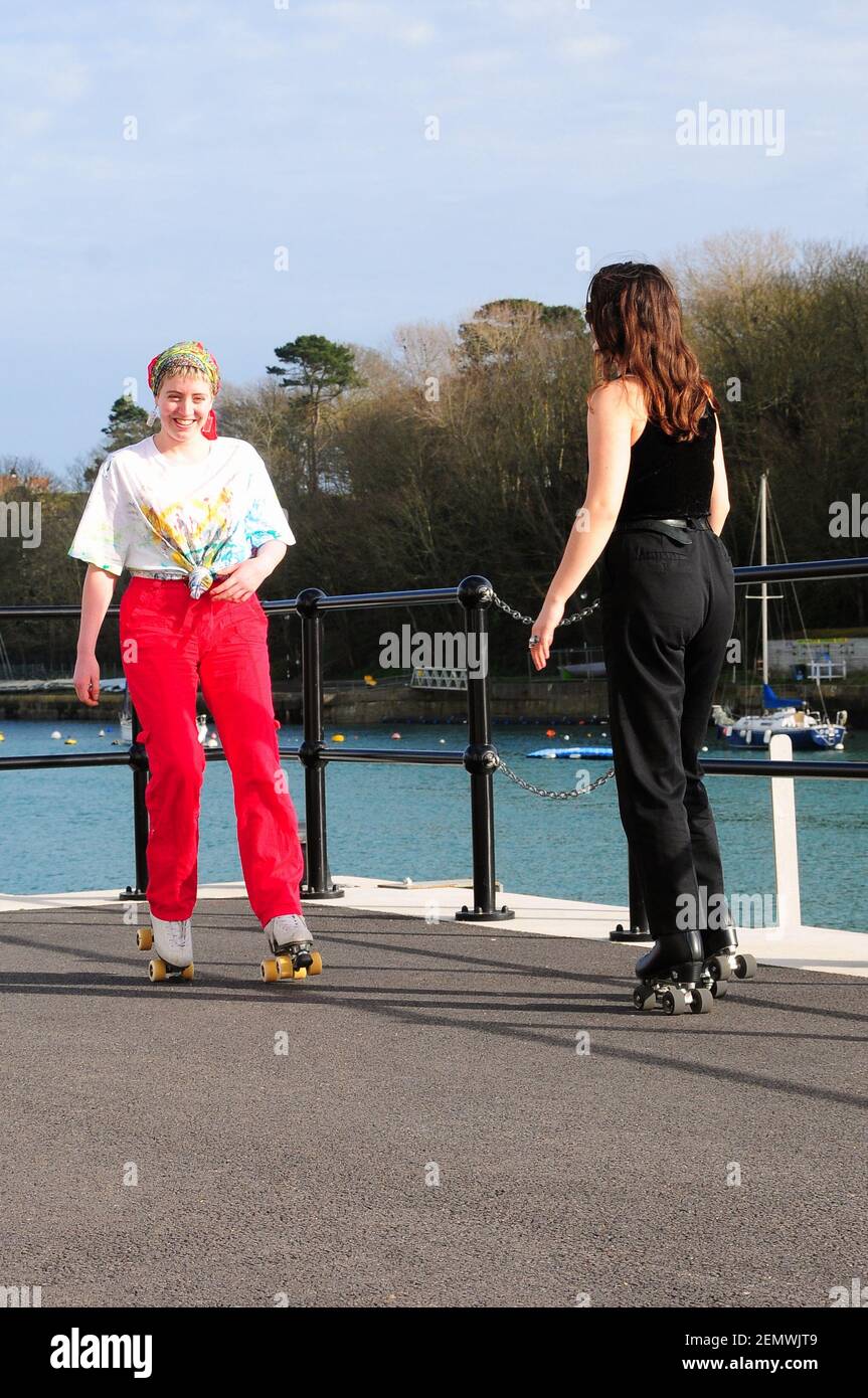 Weymouth. 25 février 2021. Météo Royaume-Uni. Deux jeunes femmes de Weymouth pratiquent leur patinage sur le port par temps chaud et peu saisonnier. Crédit : stuart fretwell/Alay Live News Banque D'Images