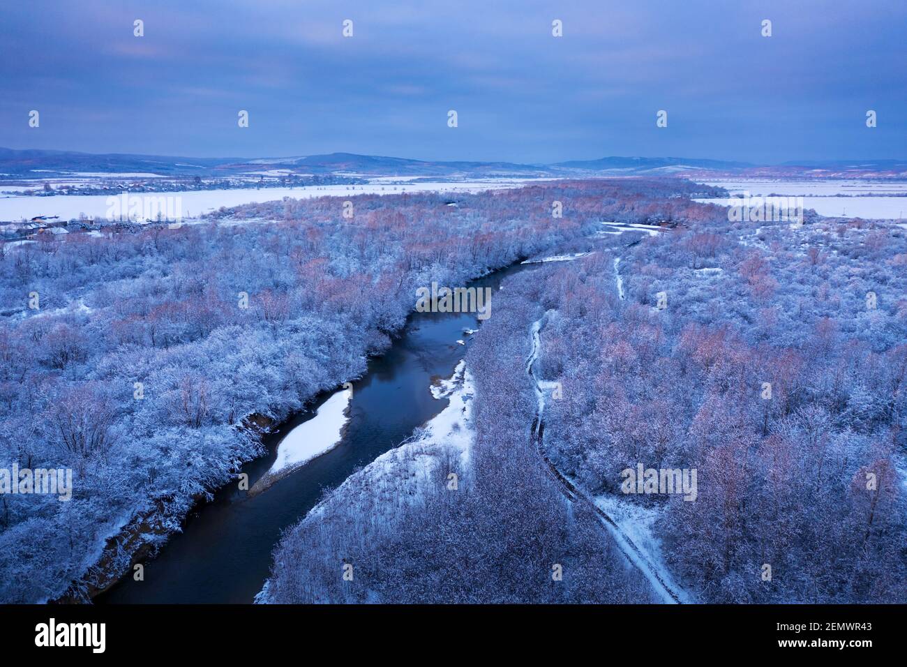 Vol à travers la rivière majestueuse, la forêt gelée et les champs d'hiver glaciaux heures de lever du soleil. Photographie de paysage Banque D'Images