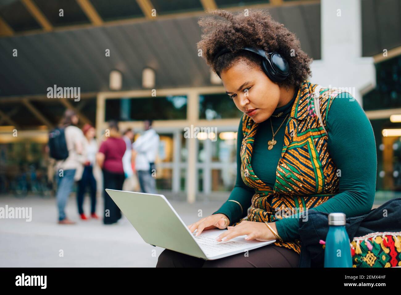 Une étudiante se concentrant tout en apprenant en ligne via un ordinateur portable à l'université campus Banque D'Images