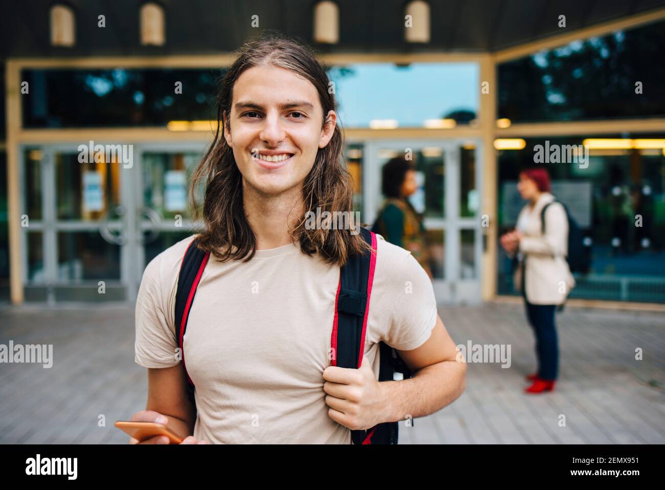 Portrait d'un étudiant de sexe masculin avec téléphone portable sur le campus universitaire Banque D'Images