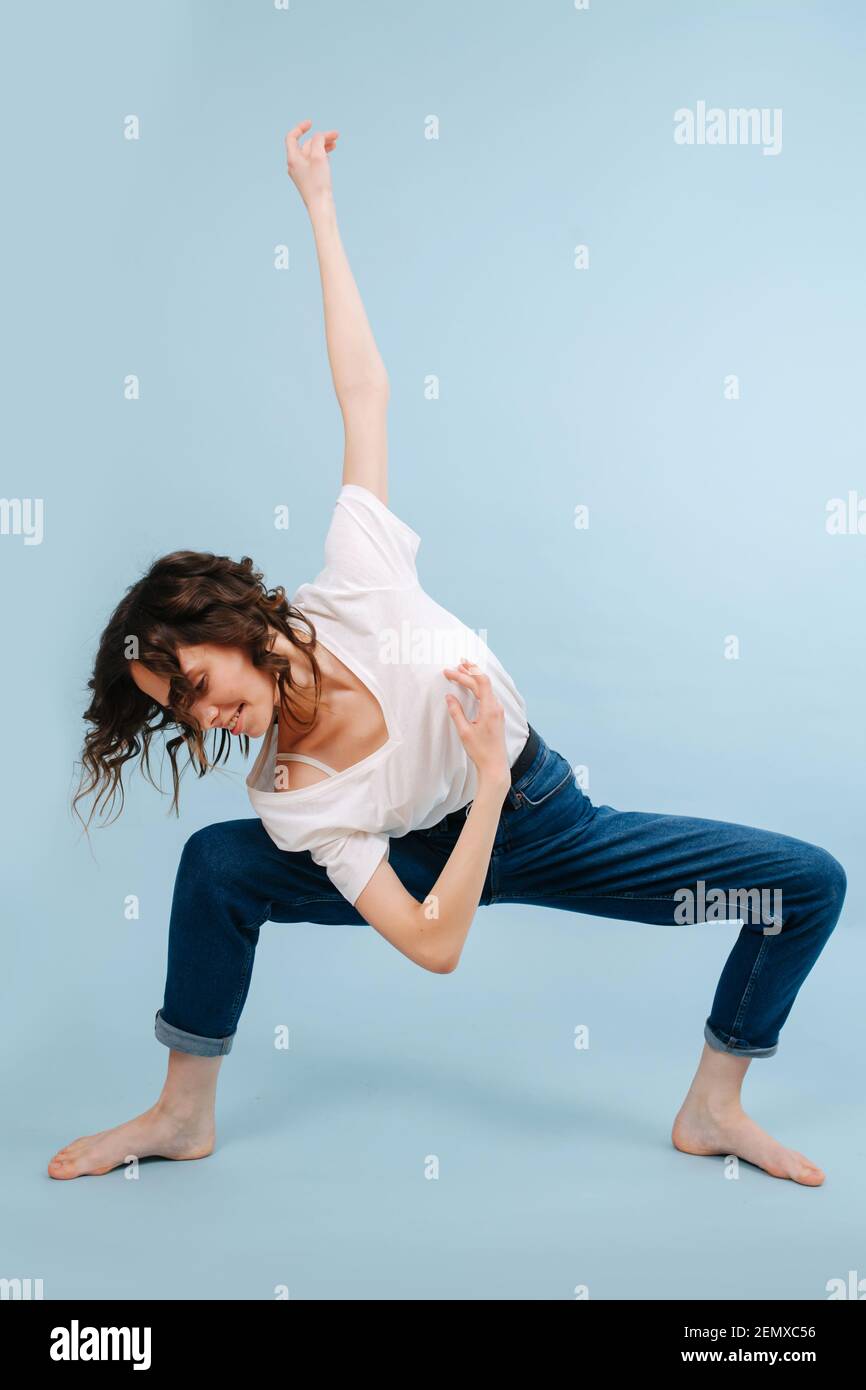 Danseuse contemporaine joyeuse avec genoux à angle droit. Rotation de son corps Banque D'Images