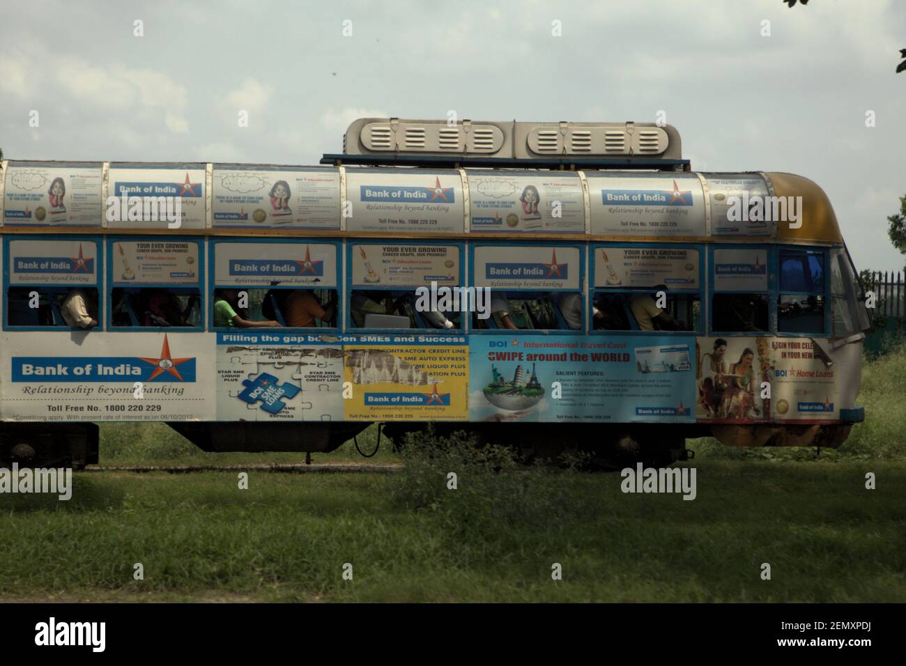 Un tram avec des annonces sur ses côtés transportant des passagers à Kolkata, Bengale-Occidental, Inde. Banque D'Images