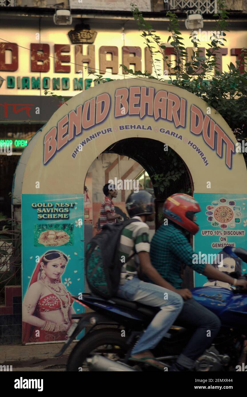 Les automobilistes qui passent devant une porte d'entrée en bord de route décorée d'une publicité devant un quartier d'affaires à Kolkata, Bengale-Occidental, Inde. Banque D'Images