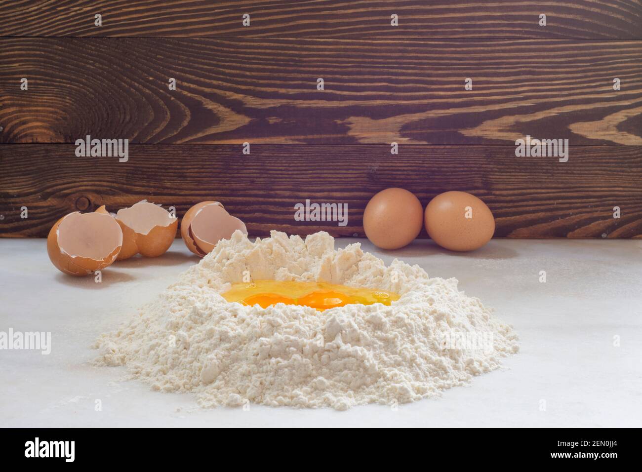 Œuf de poulet cru et farine sur fond blanc, plats faits maison, pâtes faites maison. Banque D'Images