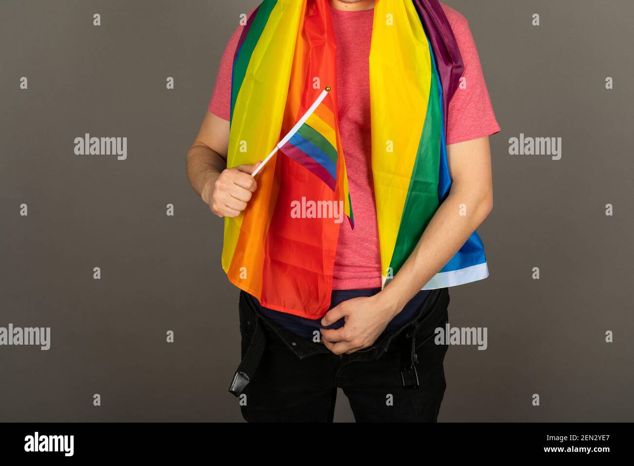 Homme gay portant un t-shirt rose et un drapeau arc-en-ciel Banque D'Images