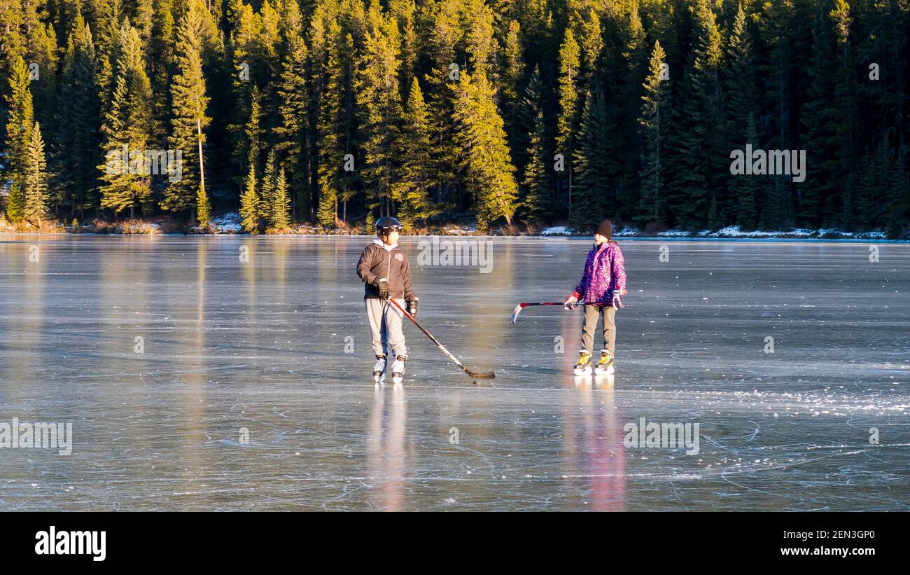 Les gens qui jouent au hockey sur un lac gelé dans le parc national Banff, au Canada Banque D'Images