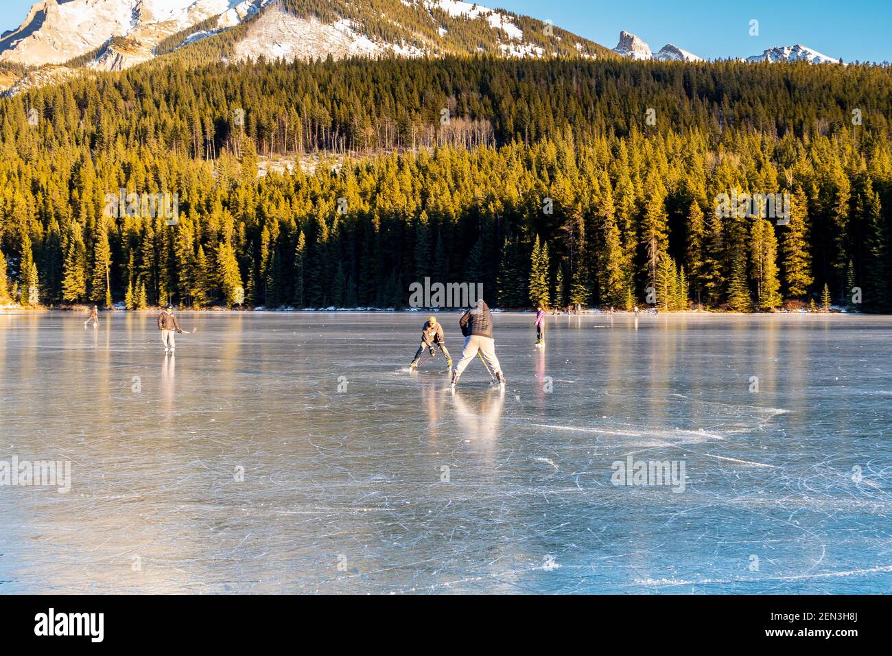 Les gens qui jouent au hockey sur un lac gelé dans le parc national Banff, au Canada Banque D'Images