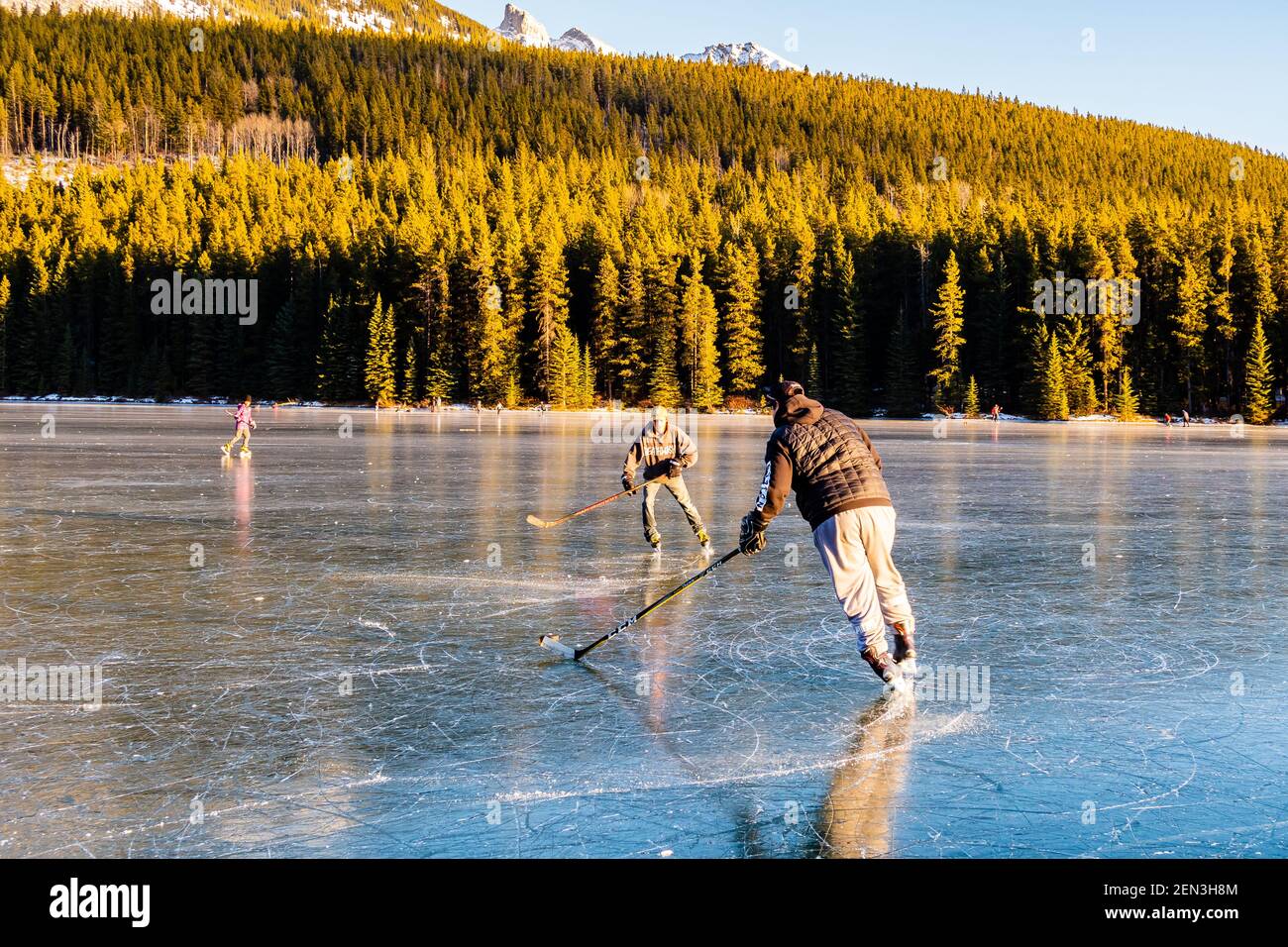 Les gens qui jouent au hockey sur un lac gelé dans le parc national Banff, au Canada Banque D'Images