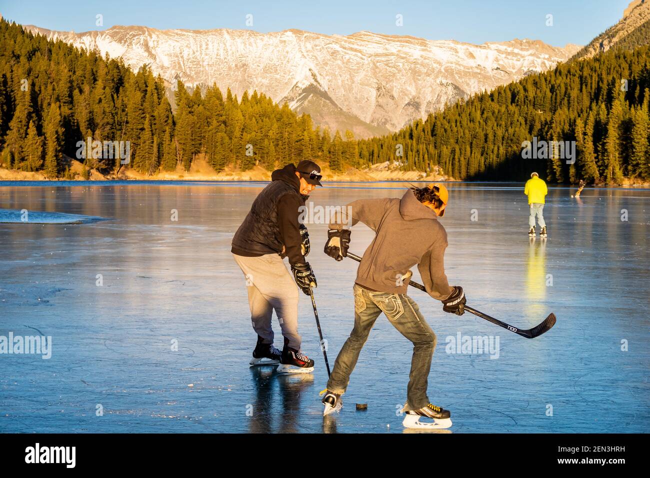 Les gens qui jouent au hockey sur un lac gelé dans le parc national Banff, au Canada Banque D'Images