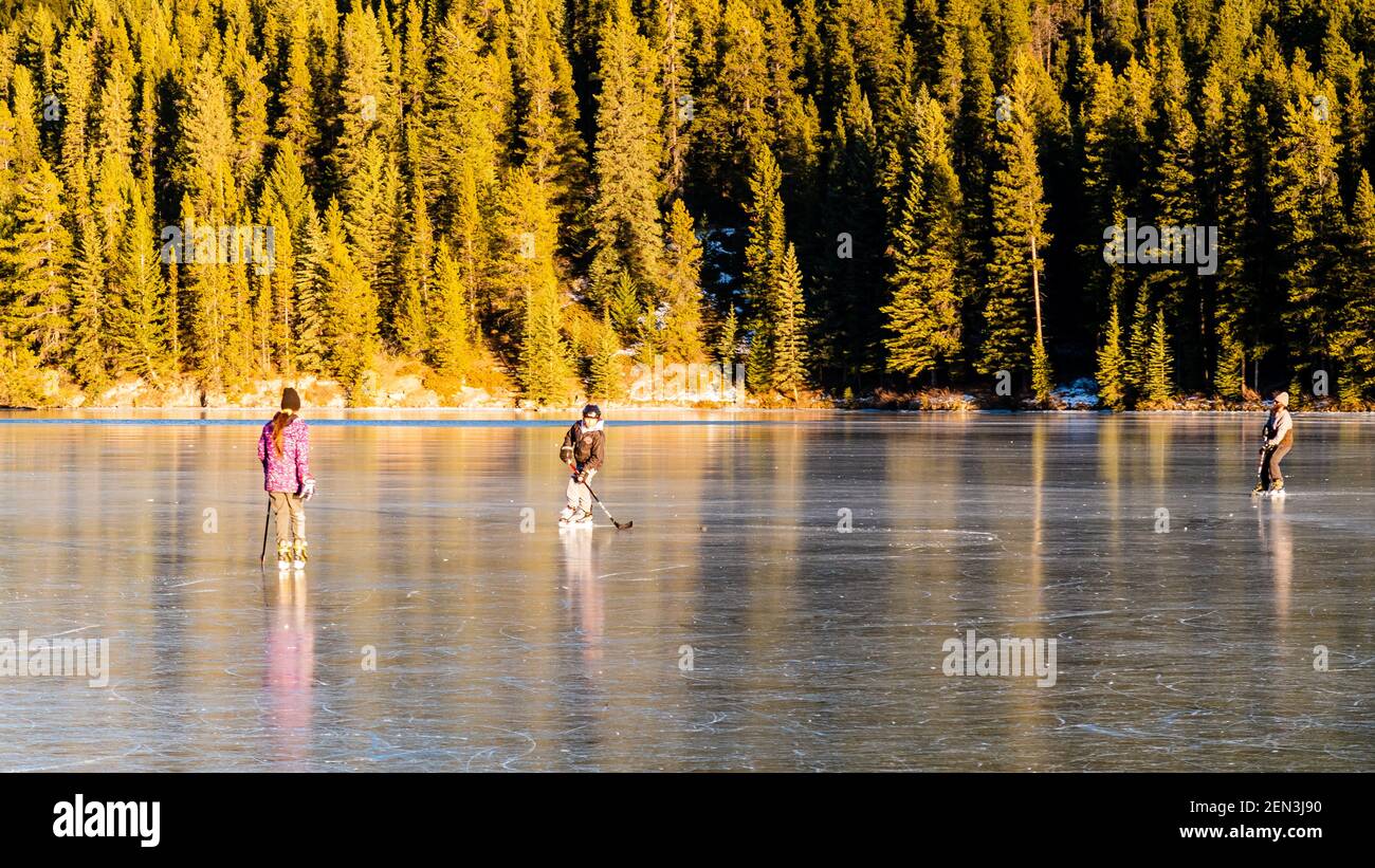 Les gens qui jouent au hockey sur un lac gelé dans le parc national Banff, au Canada Banque D'Images