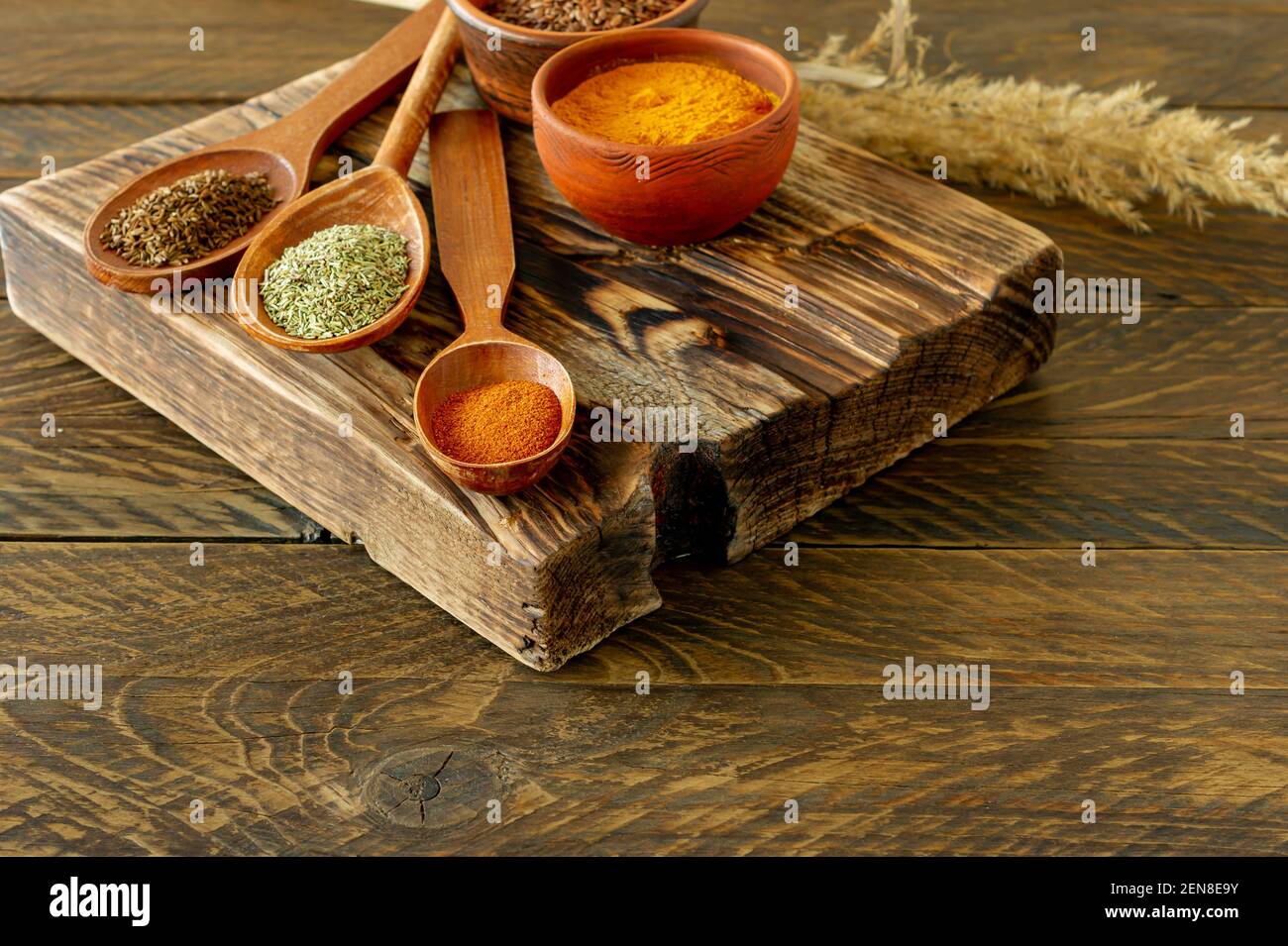 Poudre d'épices sur des cuillères sur fond de bois. Banque D'Images