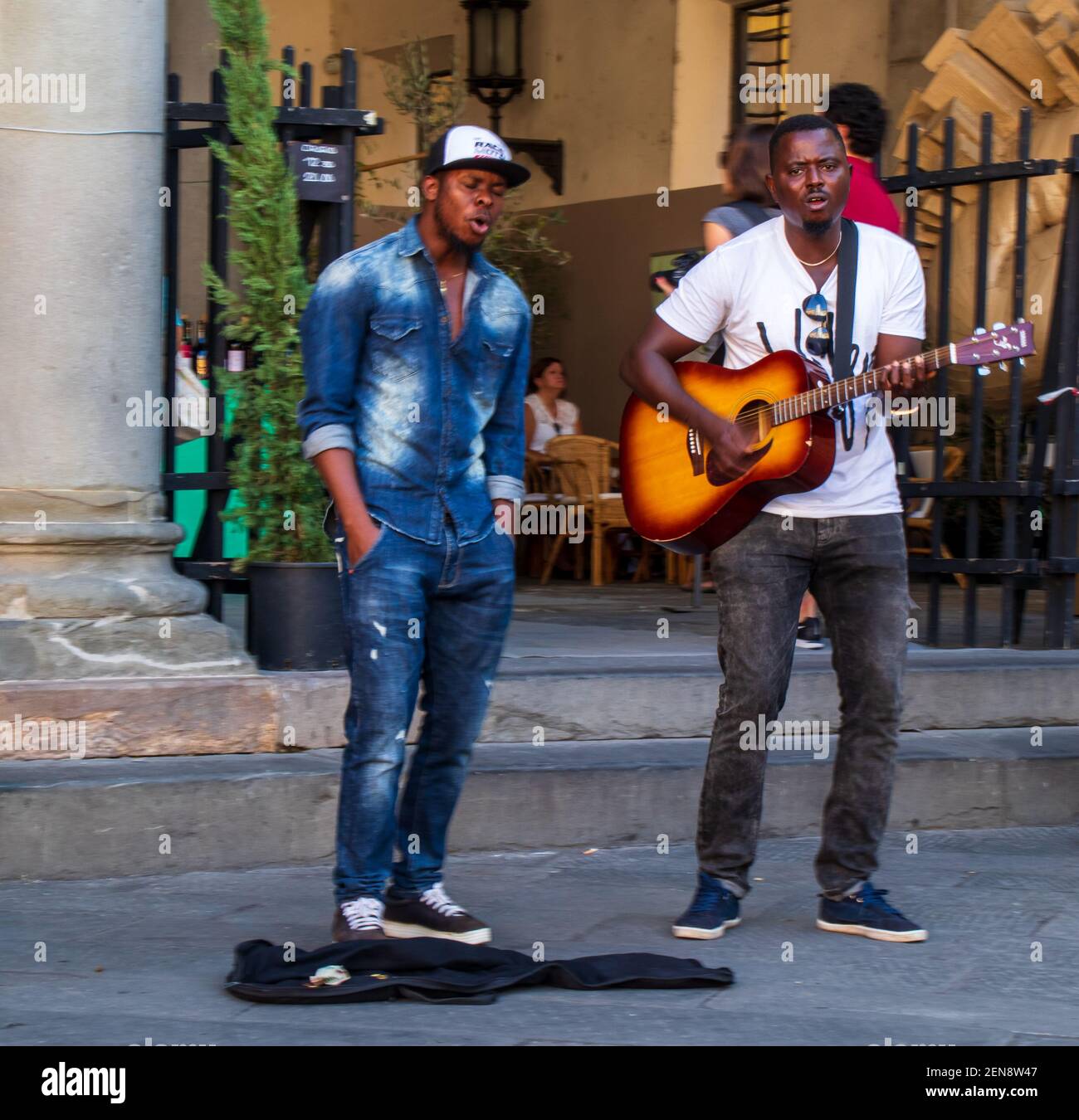 Des hommes d'Afircan chantent sur la Piazza San Michele, Lucca, Toscane où il y a une dégustation de vins le soir, des cafés en plein air et des divertissements pour les enfants. Banque D'Images