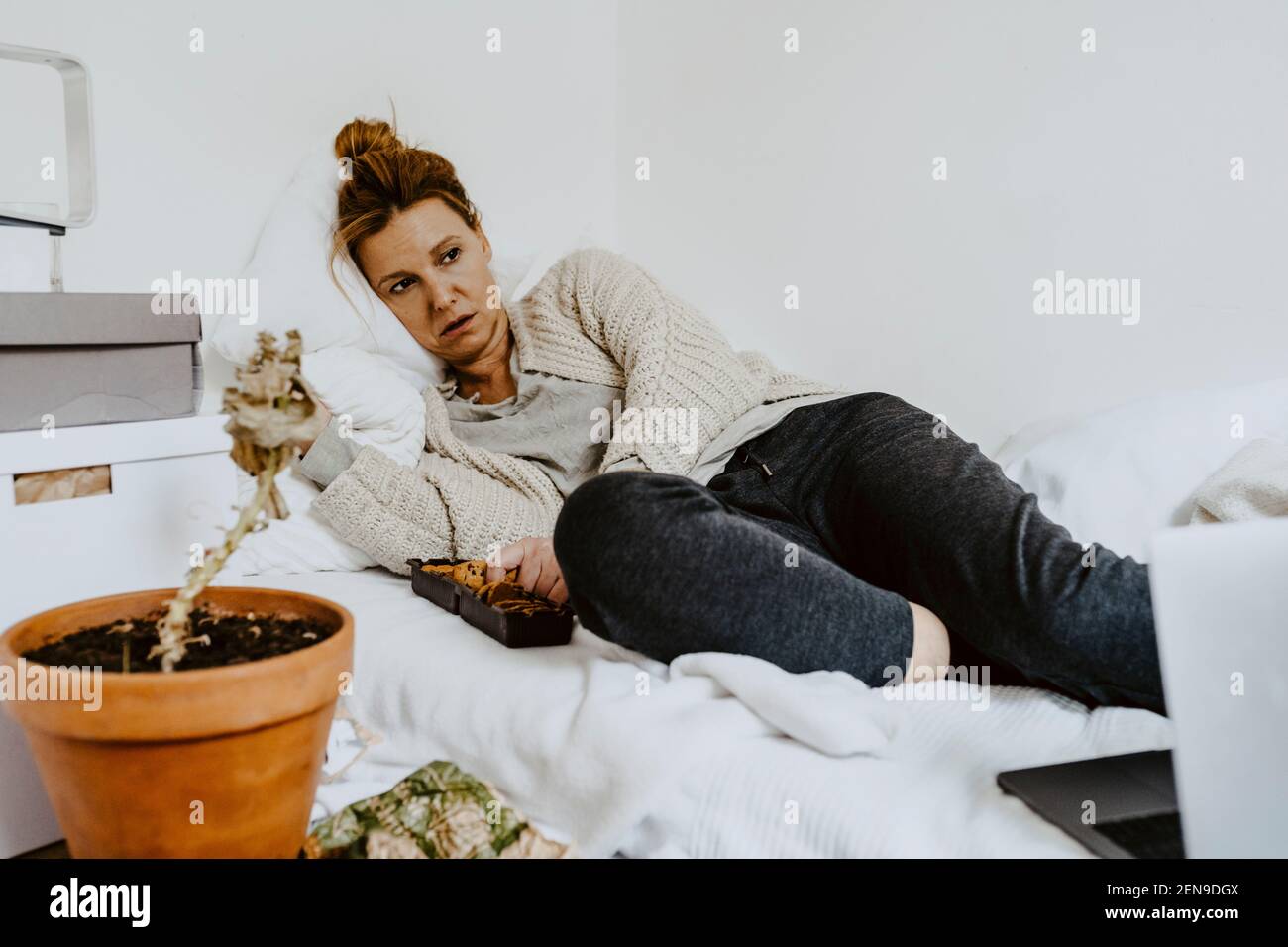 Femme mature avec trouble de l'alimentation couché sur le lit à la maison Banque D'Images