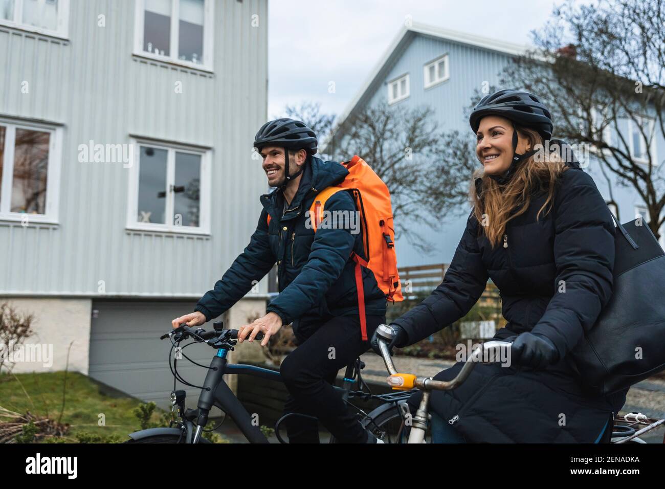 Couple souriant à vélo tout en explorant la ville Banque D'Images