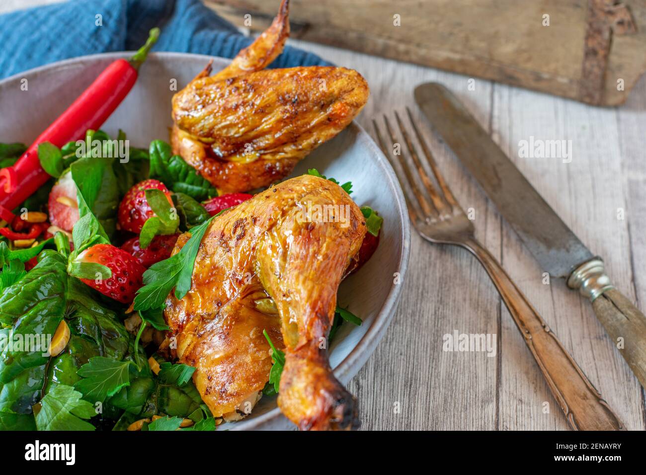 Salade verte avec poulet épicé sur une assiette avec rustique couteau et fourche Banque D'Images