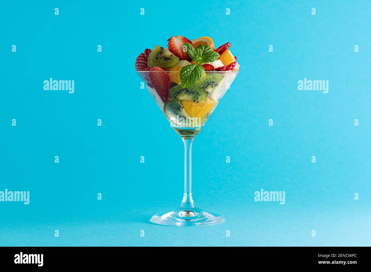 Cocktail de fruits en verre martini sur fond lumineux. Concept végétalien alimentaire minimal. Banque D'Images