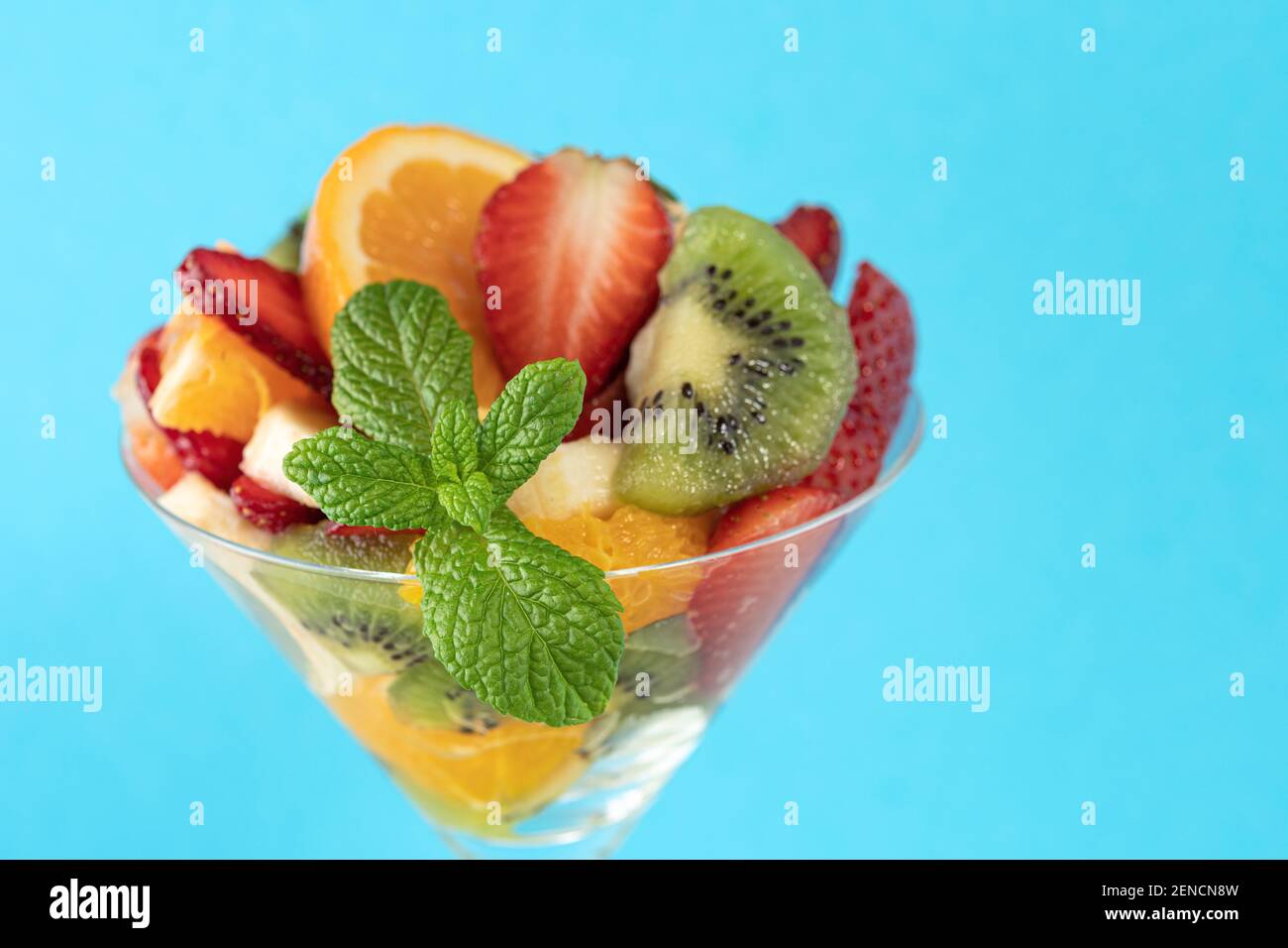 Cocktail de fruits en verre martini sur fond lumineux. Concept végétalien alimentaire minimal. Banque D'Images