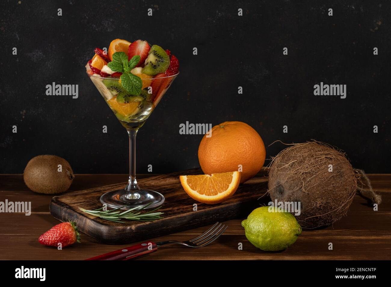 Cocktail de fruits en verre martini sur table en bois. Concept végétalien alimentaire. Banque D'Images