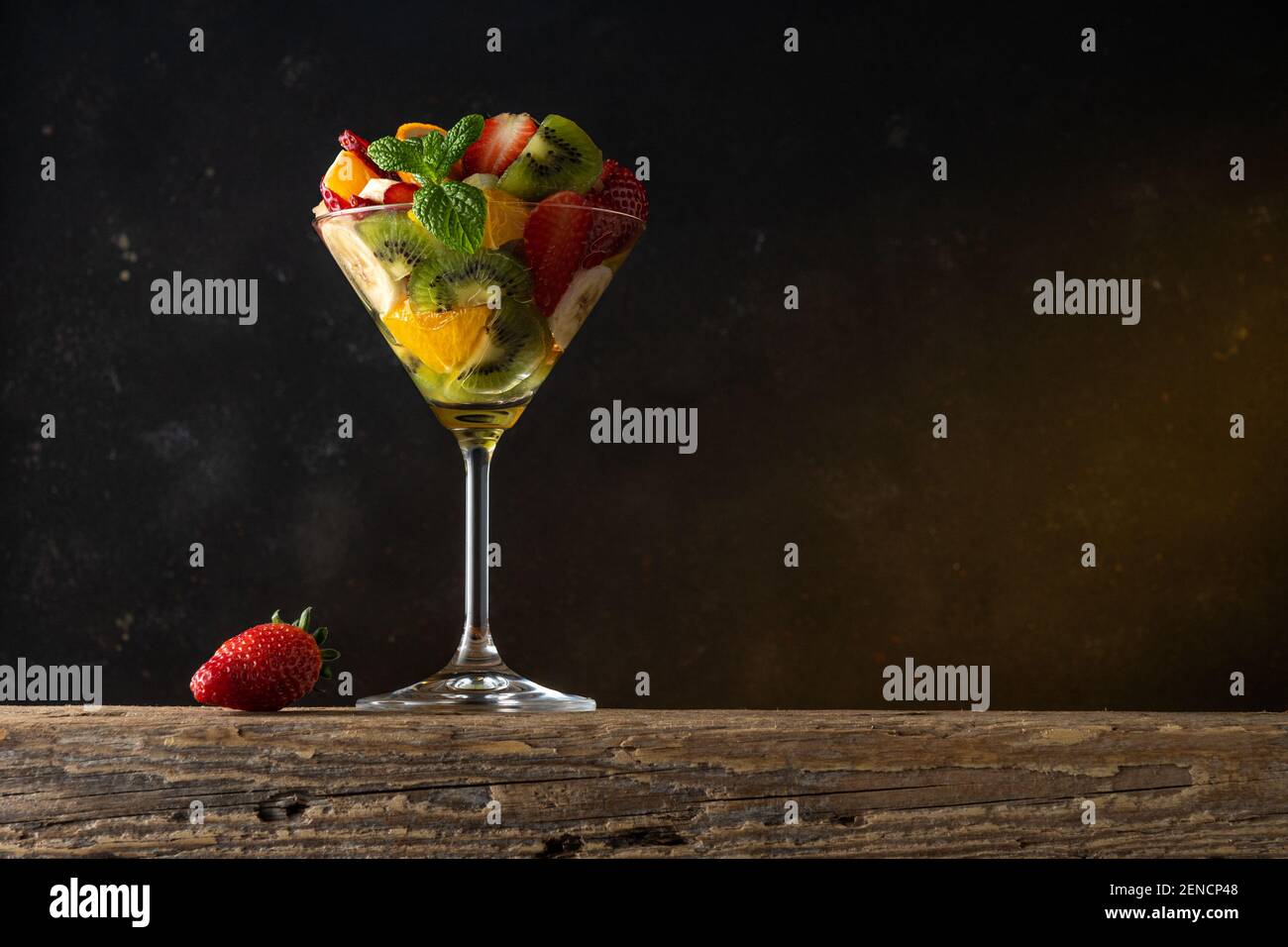 Cocktail de fruits en verre martini sur table en bois. Concept végétalien alimentaire. Banque D'Images