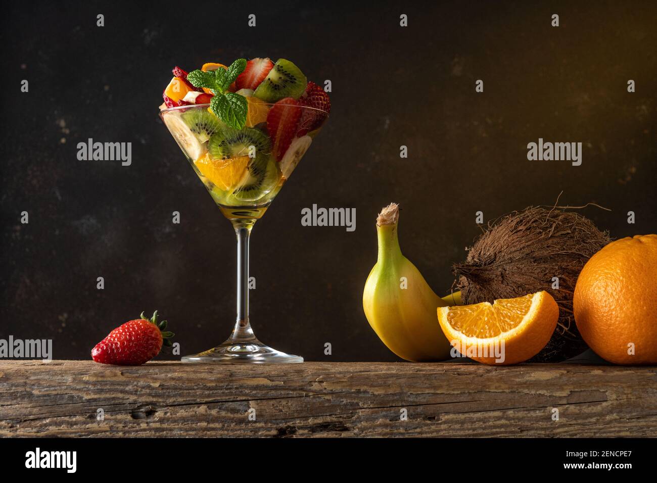 Cocktail de fruits en verre martini sur table en bois. Concept végétalien alimentaire. Banque D'Images