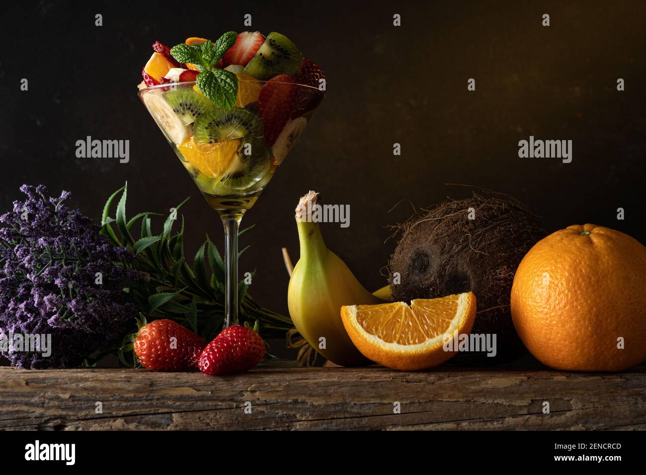 Cocktail de fruits en verre martini sur table en bois. Concept végétalien alimentaire. Banque D'Images