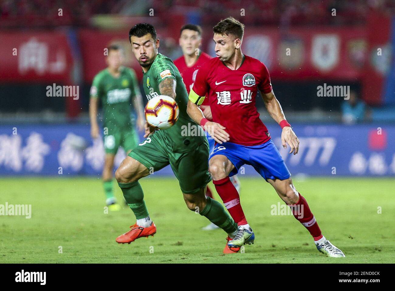 Le joueur de football brésilien Olivio da Rosa, également connu sous le nom d'Ivo, à droite, de Henan Jianye passe le ballon contre le joueur de football anglais Nico Yennaris, connu en Chine sous le nom de Li Ke, de Beijing Sinobo Guoan dans leur 20ème tour de match lors de la Super League (CSL) 2019 de l'Association chinoise de football à Zhengzhou, Province de Henan en Chine centrale, 27 juillet 2019. Henan Jianye a battu Beijing Sinobo Guoan 1-0. (Photo de Stringer - Imaginechina/Sipa USA) Banque D'Images