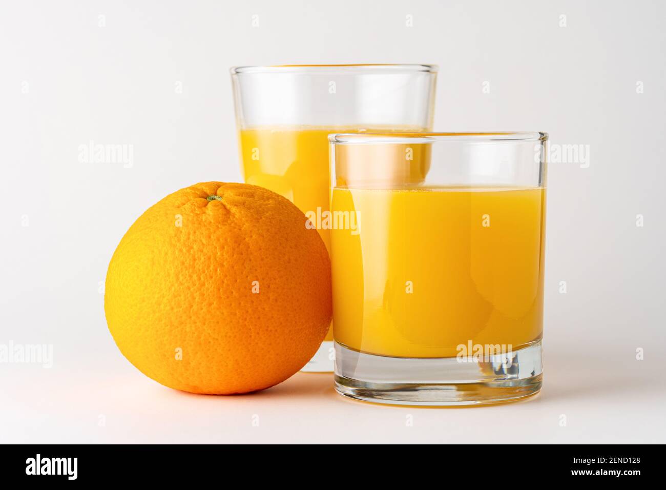 Deux verres de jus d'orange sur fond blanc. Concept fruit. Banque D'Images