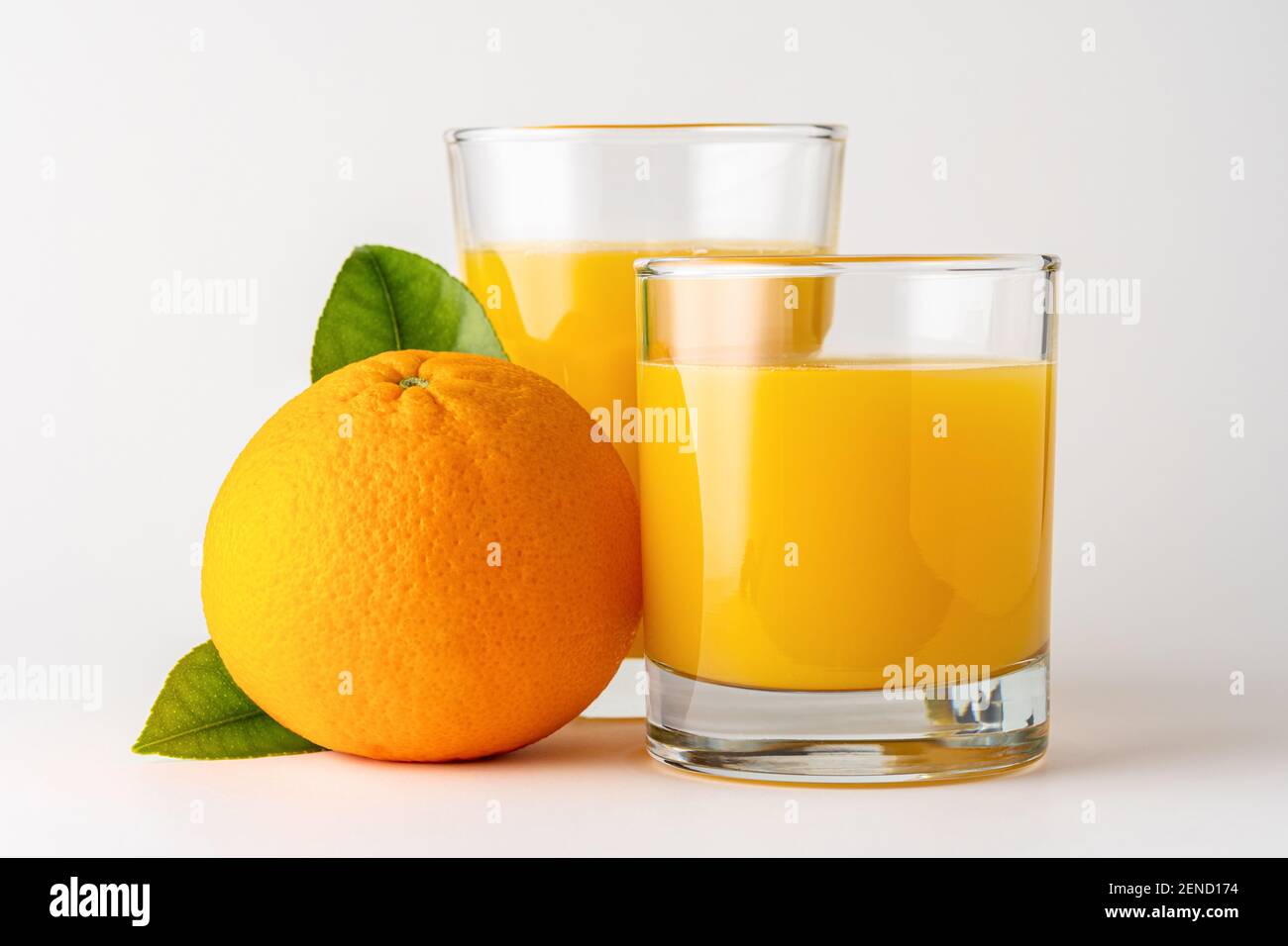 Deux verres de jus d'orange sur fond blanc. Concept fruit. Banque D'Images