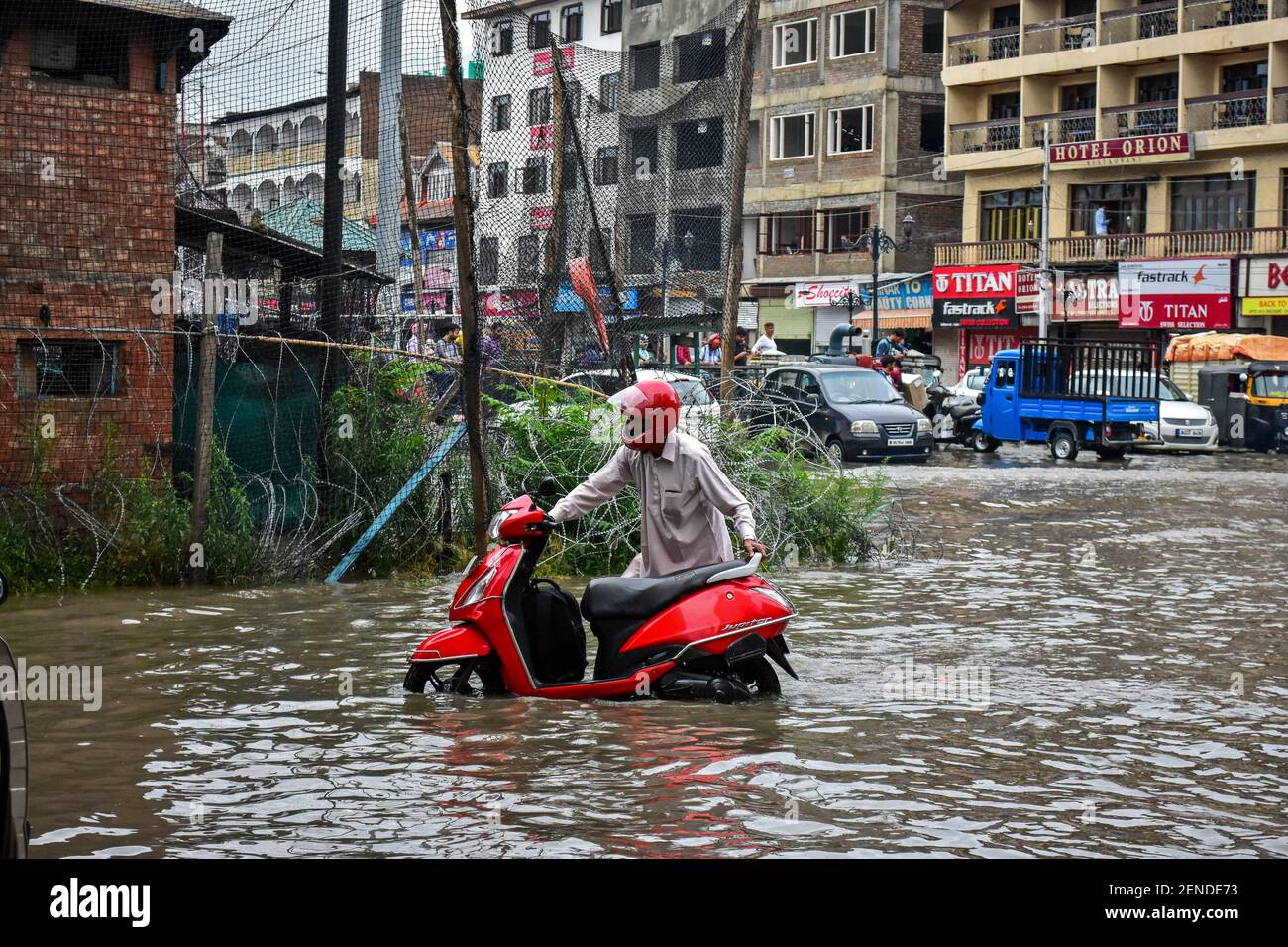 Un homme pousse son Scooter à travers une route à eau après les fortes pluies à Srinagar. Les pluies ont causé l'exploitation de l'eau dans de nombreuses zones de Srinagar, ce qui a révélé le mauvais système de drainage de la ville. Le service météorologique a prévu de fortes précipitations pour les prochains jours dans toute la région. (Photo de Saqib Majeed / SOPA Images / Sipa USA) Banque D'Images