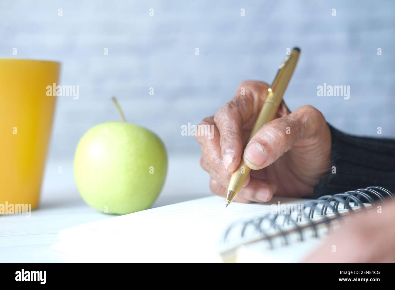 Gros plan sur l'écriture de main de femmes âgées sur le bloc-notes. Banque D'Images