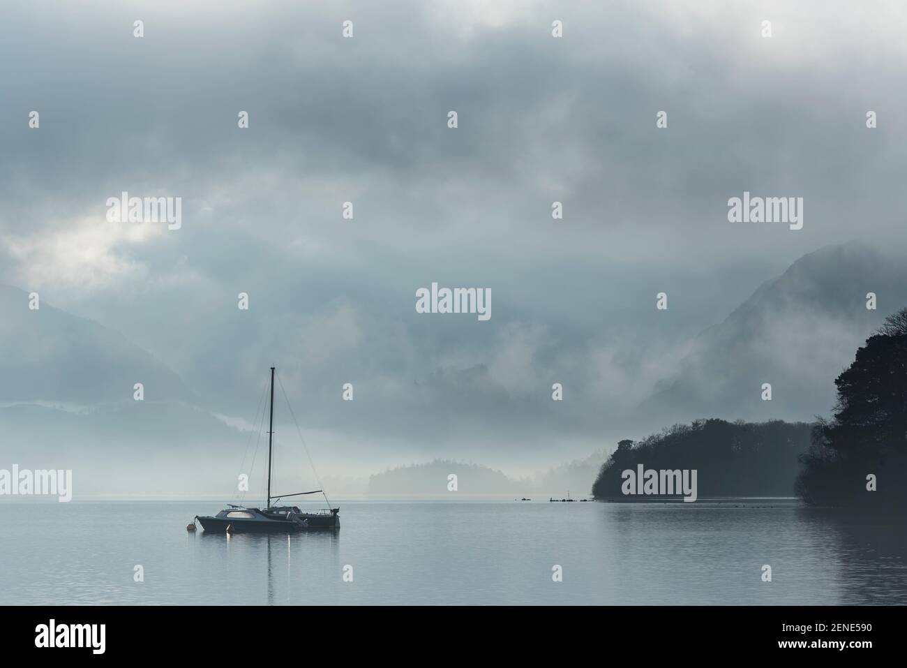 Image de paysage épique regardant à travers Derwentwater dans Lake District vers Catbells a enneigé la montagne avec un épais brouillard qui se balade dans la vallée Banque D'Images