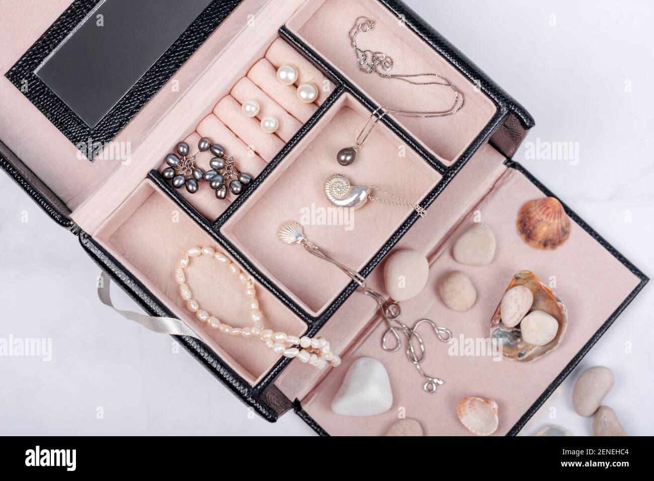 Collection de bijoux de mer en boîte à bijoux sur fond de marbre clair avec  coquillages et galets. Collier en perles, boucles d'oreilles en perles et  chaînes argentées Photo Stock - Alamy