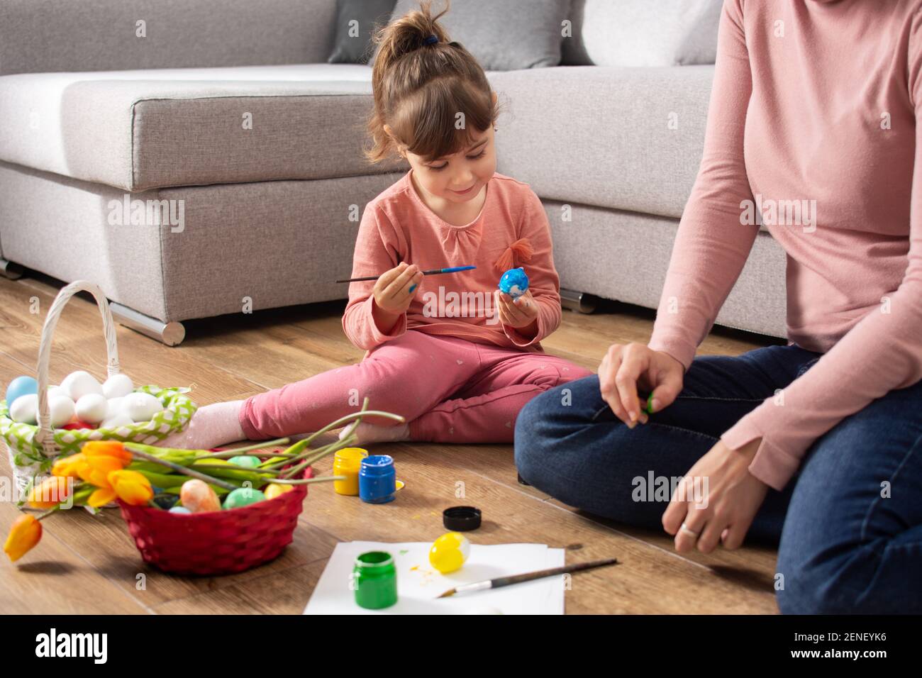 Une mère et sa fille peignant des œufs de Pâques à la maison. Banque D'Images