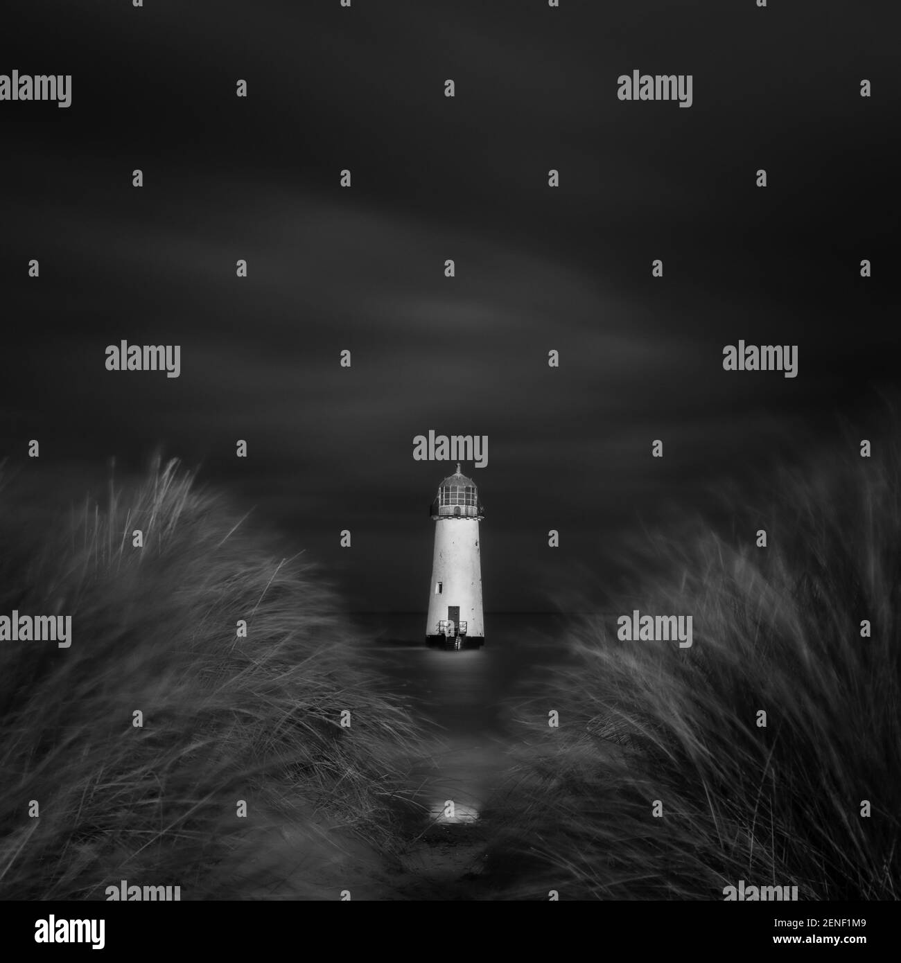 Les dunes de sable herbeuses constituent un rideau parfait pour le phare de point of Ayr dans le nord du pays de Galles. Banque D'Images