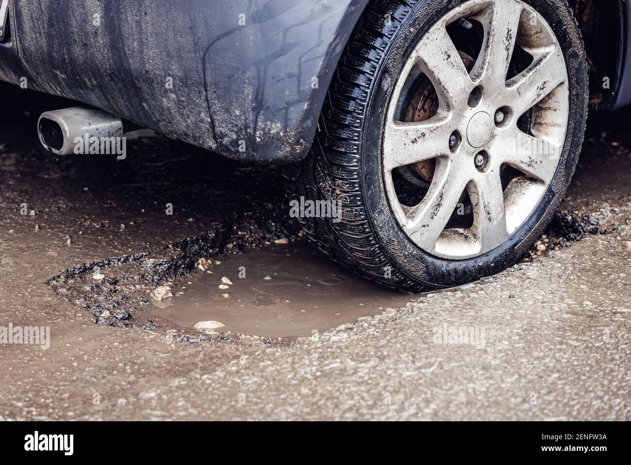 pneu de voiture dans le grand nid d'poule sur la route Photo Stock - Alamy