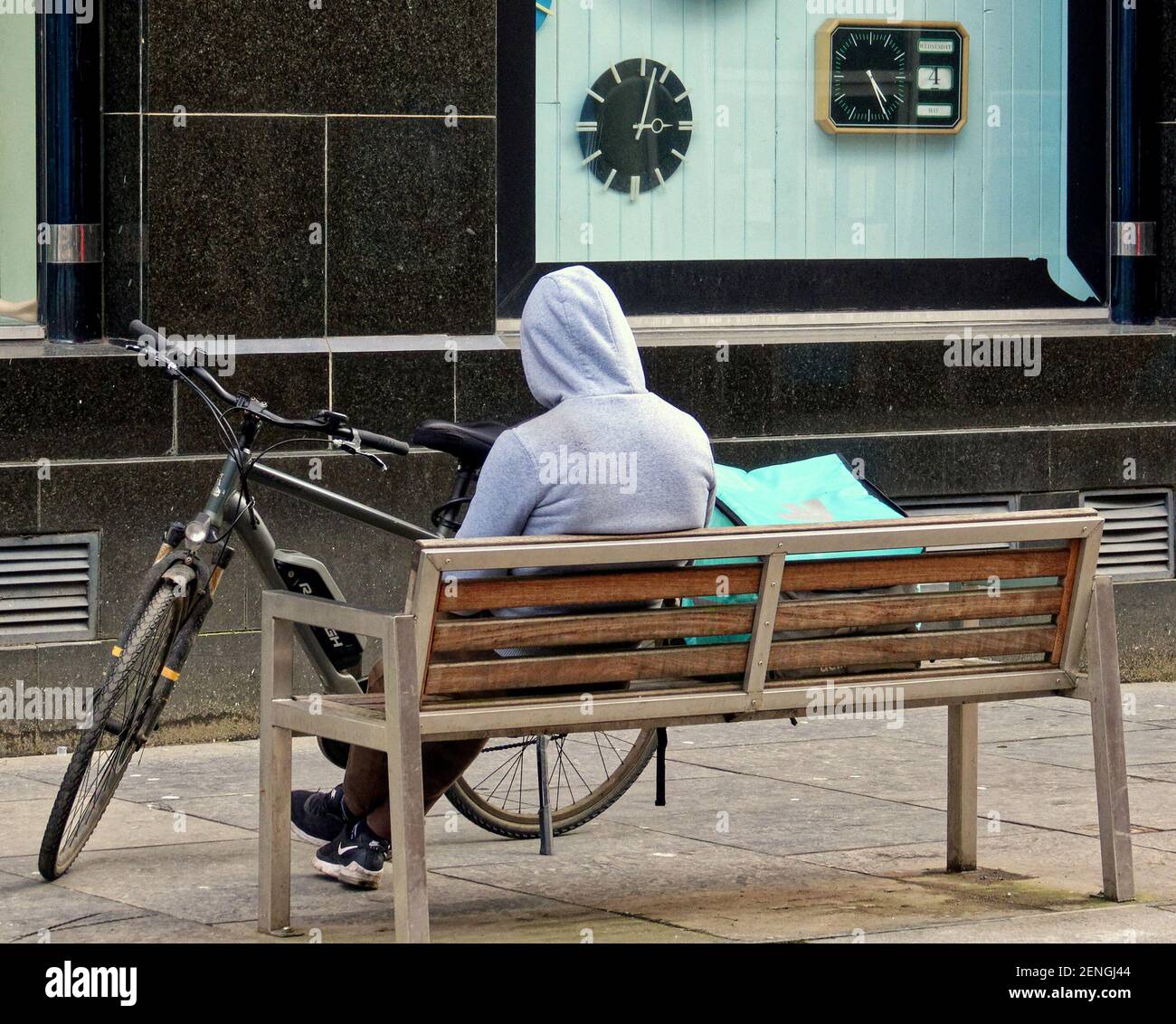 Glasgow, Écosse, Royaume-Uni, 26 février 2021, LockDown Friday a vu le temps ensoleillé pendant que les gens continuent à se promener seuls sans but dans le centre-ville vide. Un cycliste deliveroo aime la récession sous le regard de plusieurs horloges. Crédit Gerard Ferry/Alay Live News Banque D'Images