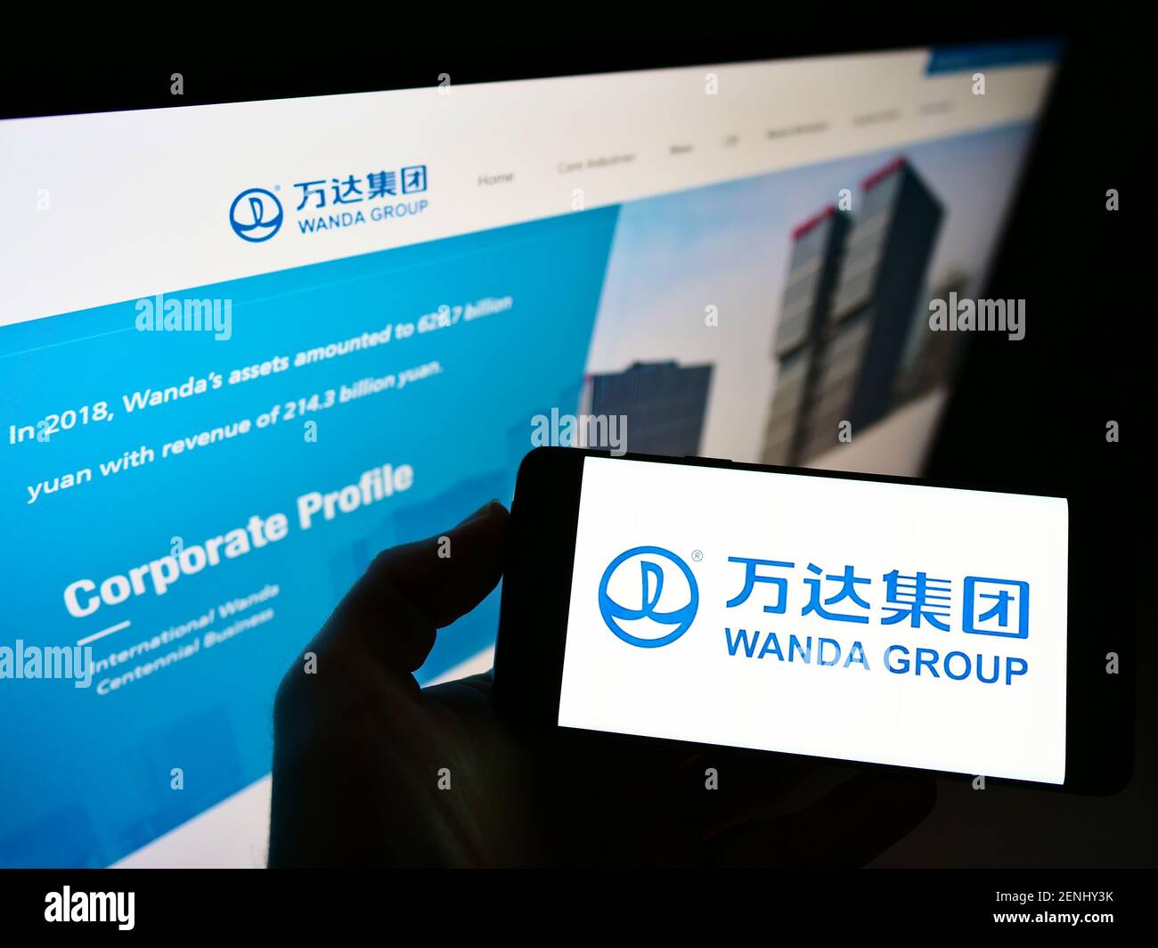 Personne tenant un téléphone mobile avec le logo d'affaires du conglomérat chinois Wanda Group sur l'écran en face de la page Web. Concentrez-vous sur l'affichage du téléphone portable. Banque D'Images